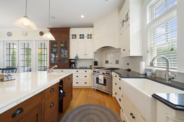 261 45th St, Avalon, NJ 08202 - kitchen with premium stove, plenty of natural light, decorative light fixtures, glass insert cabinets, and recessed lighting