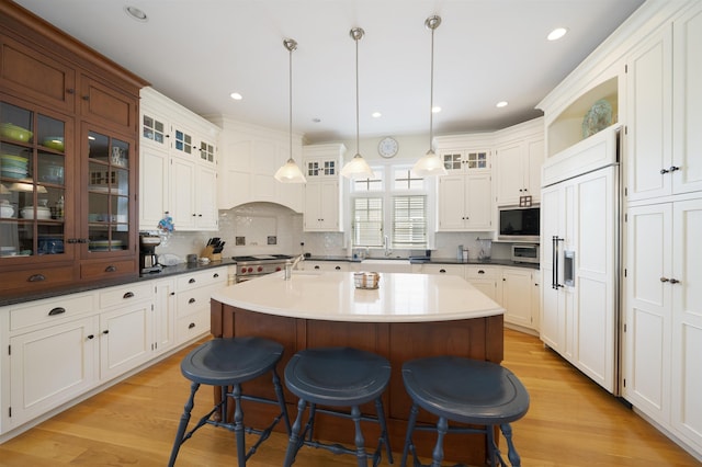 261 45th St, Avalon, NJ 08202 - kitchen featuring built in appliances, a breakfast bar, a center island with sink, backsplash, and recessed lighting