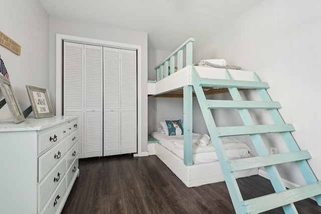 bedroom with dark hardwood / wood-style floors and a closet