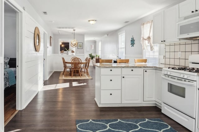 kitchen with white cabinets, white appliances, and kitchen peninsula