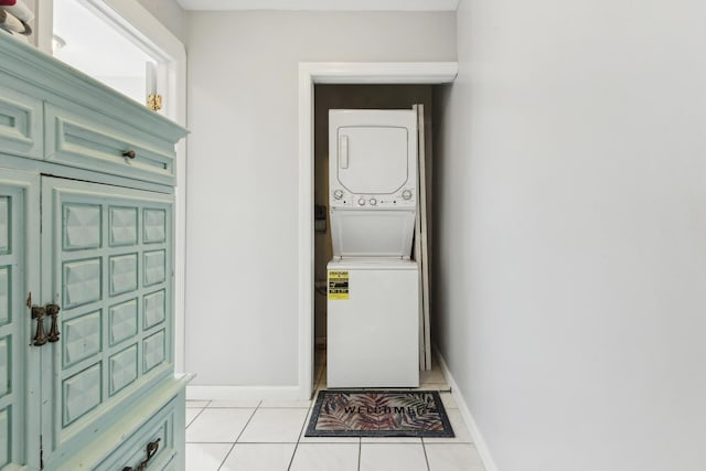 washroom featuring stacked washer and dryer and light tile patterned flooring