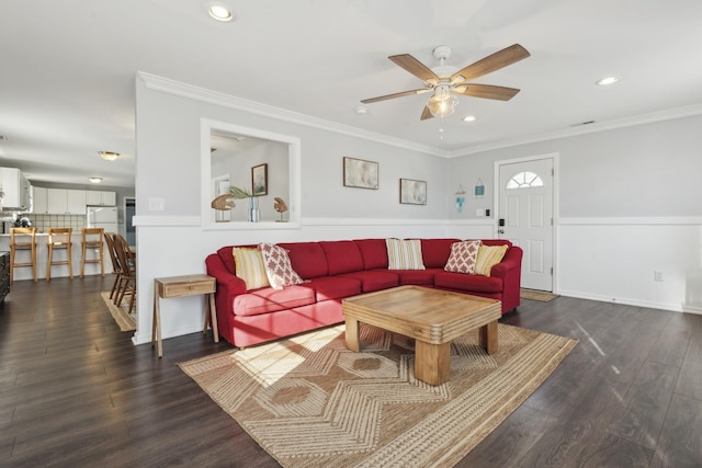 living room featuring dark wood-type flooring, ceiling fan, and ornamental molding