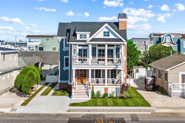 1819 Dune Dr, Avalon, NJ 08202 - view of front of house featuring a balcony, a porch, a residential view, a chimney, and board and batten siding
