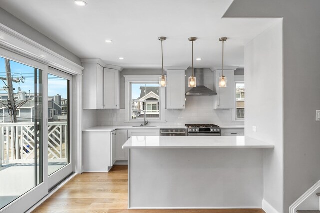 297 24th St Unit 297, Avalon, NJ 08202 - kitchen featuring wall chimney exhaust hood, plenty of natural light, decorative backsplash, light countertops, and recessed lighting