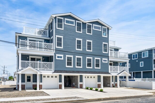 297 24th St Unit 297, Avalon, NJ 08202 - view of front of house featuring a garage, a balcony, driveway, brick siding, and fence