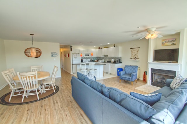 living room featuring light hardwood / wood-style flooring and ceiling fan