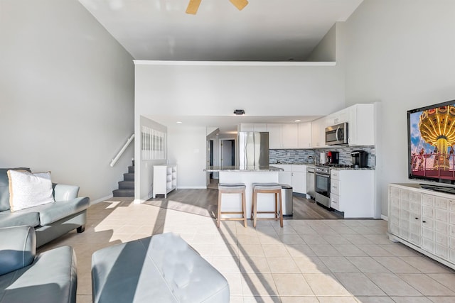 5111 Shawcrest Rd Unit 5111, Lower Township, NJ 08260 - living area featuring light tile patterned floors, a towering ceiling, stairway, and ceiling fan