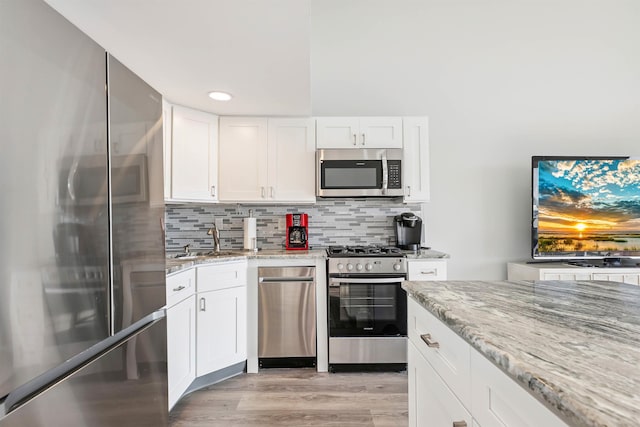 5111 Shawcrest Rd Unit 5111, Lower Township, NJ 08260 - kitchen featuring stainless steel appliances, light stone countertops, white cabinetry, tasteful backsplash, and light wood-type flooring