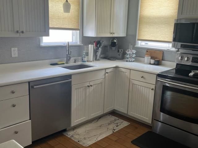 113 W Walnut Ave, North Wildwood, NJ 08260 - kitchen featuring appliances with stainless steel finishes, dark wood-type flooring, light countertops, and white cabinets