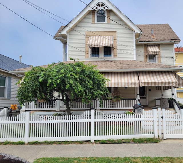 113 W Walnut Ave, North Wildwood, NJ 08260 - view of front of house with covered porch, roof with shingles, a fenced front yard, and a gate