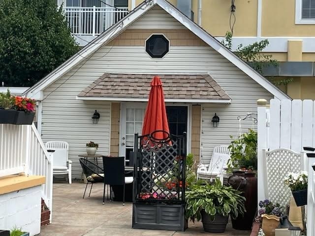 113 W Walnut Ave, North Wildwood, NJ 08260 - back of house with a shingled roof, outdoor dining space, and a patio area