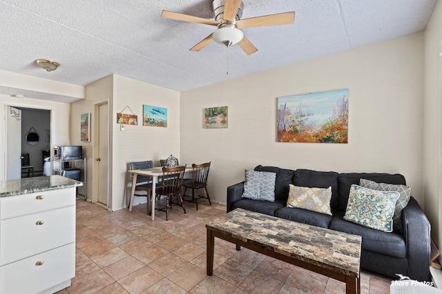 living room featuring ceiling fan and a textured ceiling