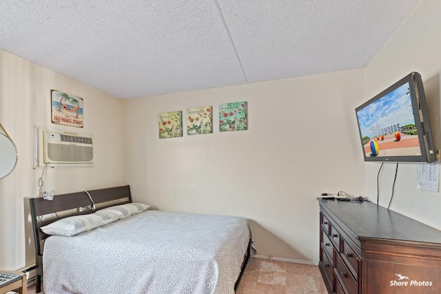 bedroom featuring a baseboard heating unit, a textured ceiling, and a wall unit AC