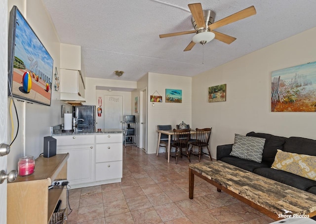 kitchen featuring ceiling fan, a textured ceiling, and white cabinets