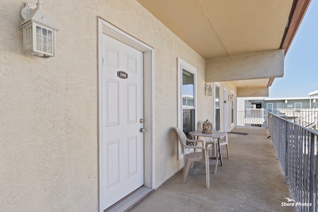 view of exterior entry with a balcony