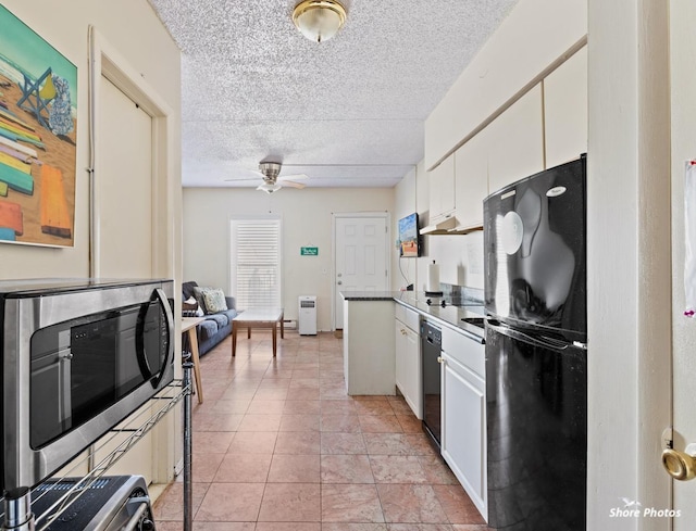 kitchen featuring ceiling fan, black fridge, white cabinets, and a textured ceiling