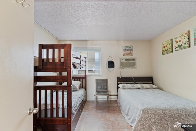 bedroom with a wall mounted air conditioner and a textured ceiling