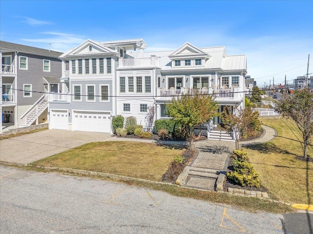 view of front of house featuring driveway, a balcony, a garage, and a front lawn