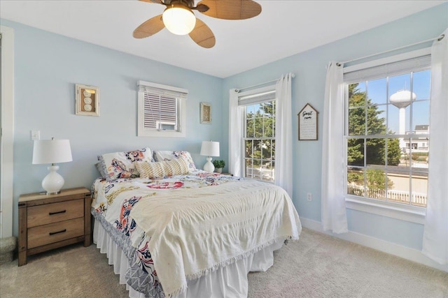 bedroom featuring light colored carpet, ceiling fan, and baseboards