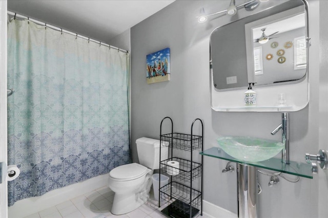 full bath featuring a ceiling fan, toilet, tile patterned floors, shower / bath combination with curtain, and a sink