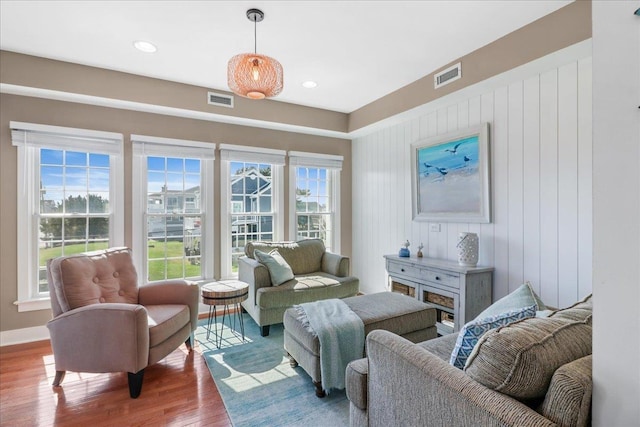 living room featuring baseboards, visible vents, wood finished floors, and recessed lighting