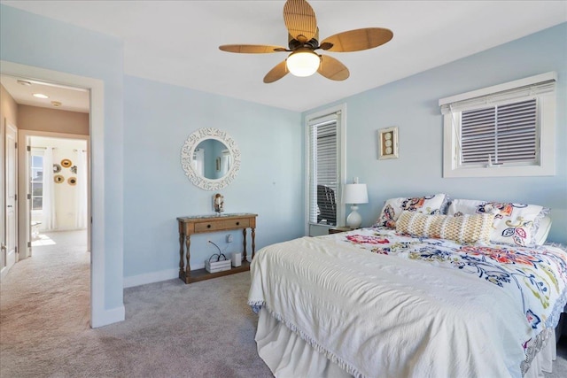 bedroom with ceiling fan, baseboards, and light colored carpet