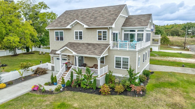 view of front facade featuring a porch, a garage, and a front lawn