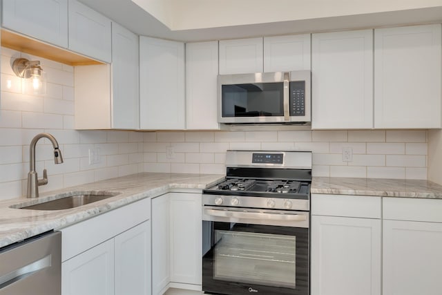 24 Heron Way N, Cape May, NJ 08204 - kitchen featuring appliances with stainless steel finishes, a sink, backsplash, and white cabinets