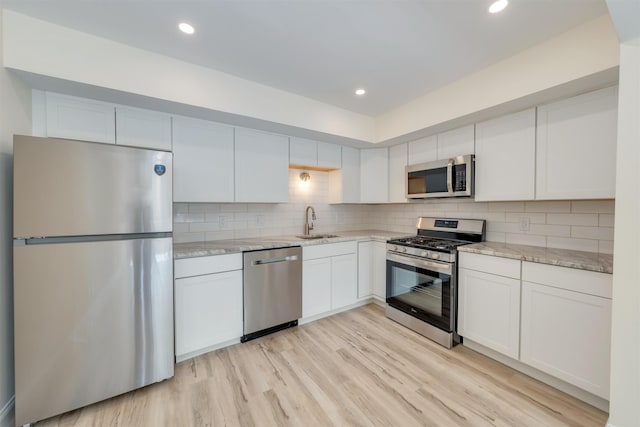 24 Heron Way N, Cape May, NJ 08204 - kitchen with appliances with stainless steel finishes, a sink, light stone counters, white cabinetry, and recessed lighting