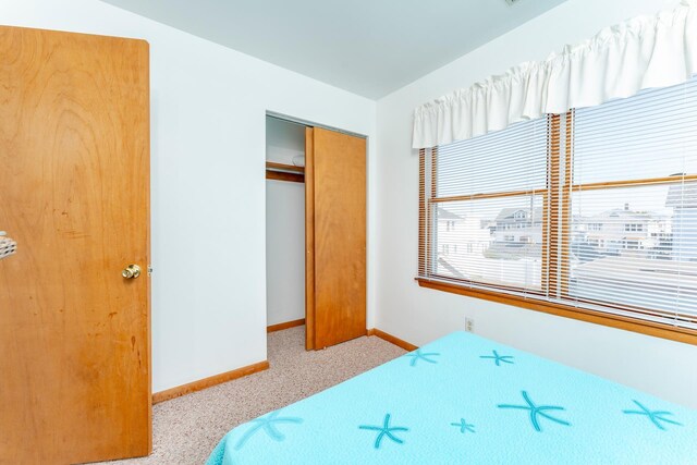 bedroom with light carpet and a closet