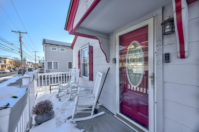 snow covered property entrance featuring a porch