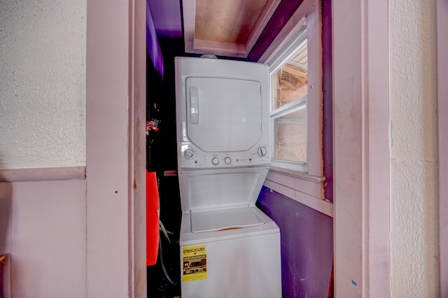 clothes washing area featuring stacked washer / dryer