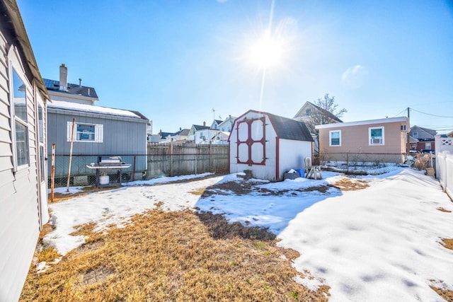 yard layered in snow with a storage shed