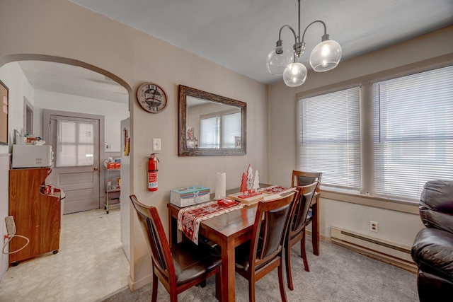 dining space with a baseboard radiator and a notable chandelier