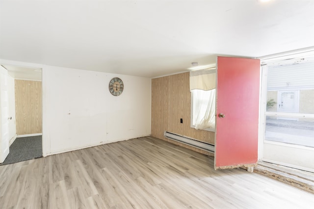 unfurnished room with a wealth of natural light, light hardwood / wood-style floors, and baseboard heating