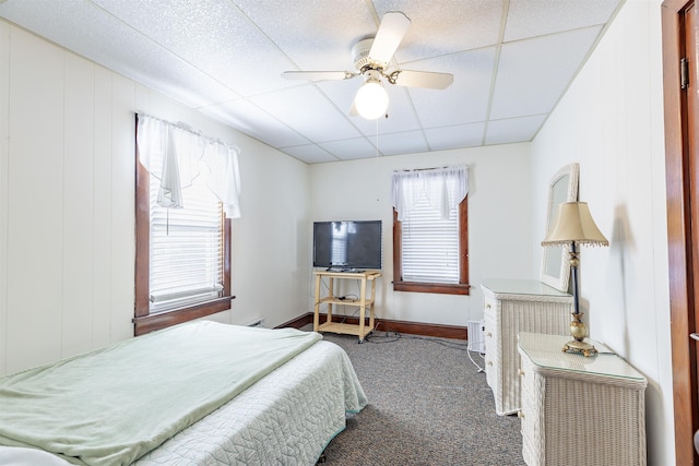 bedroom featuring a paneled ceiling, ceiling fan, and dark carpet
