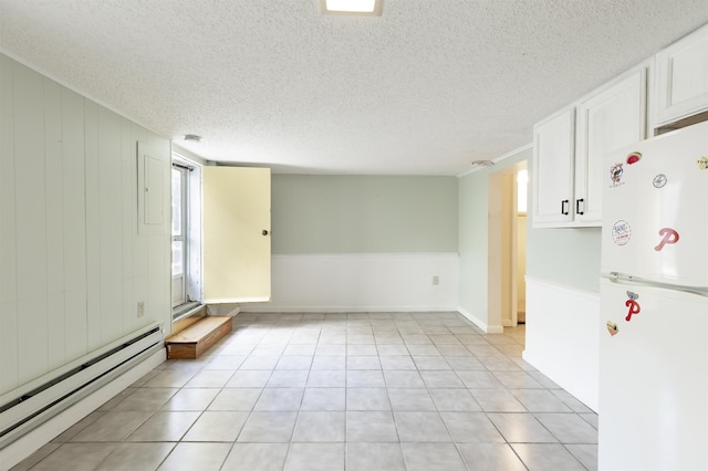 tiled empty room featuring a textured ceiling and a baseboard heating unit
