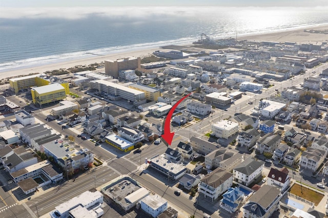 drone / aerial view featuring a water view and a view of the beach