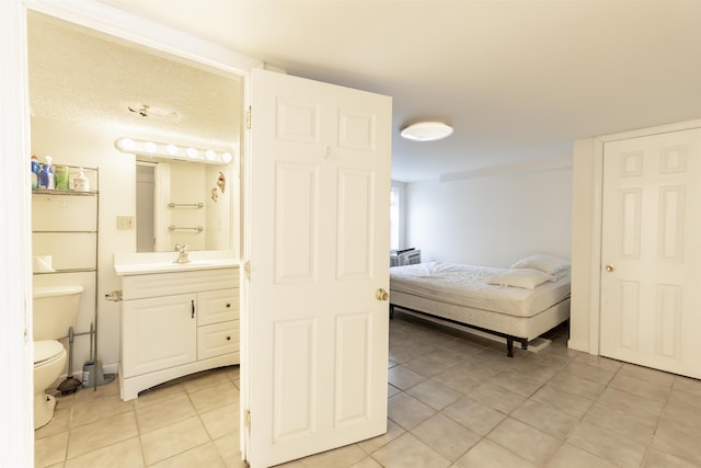 bedroom with sink and light tile patterned floors