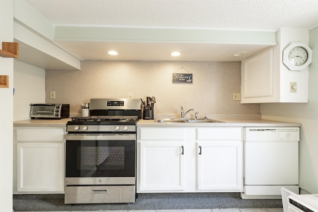 kitchen featuring dishwasher, stainless steel gas stove, white cabinets, and sink