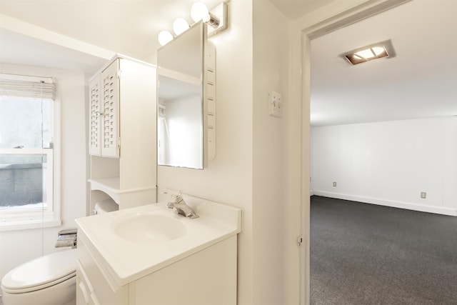 bathroom featuring vanity, a healthy amount of sunlight, and toilet