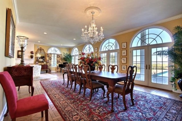 dining room with an inviting chandelier, ornamental molding, a wealth of natural light, and french doors