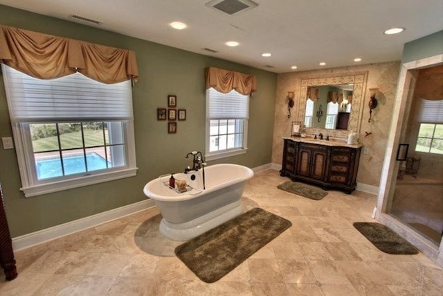 bathroom with vanity, a healthy amount of sunlight, and plus walk in shower