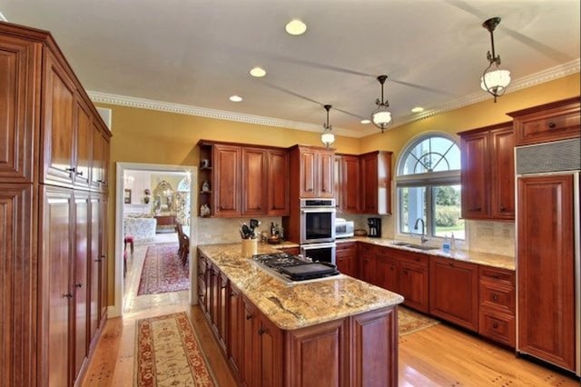 kitchen with sink, light stone countertops, appliances with stainless steel finishes, tasteful backsplash, and decorative light fixtures