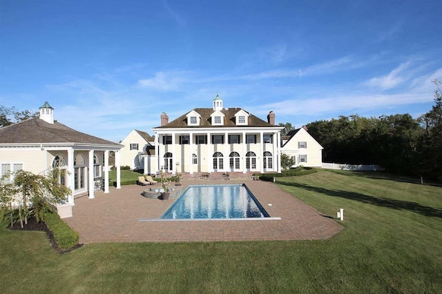 rear view of house with a lawn and a patio