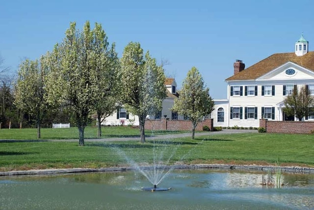 exterior space with a water view and a lawn