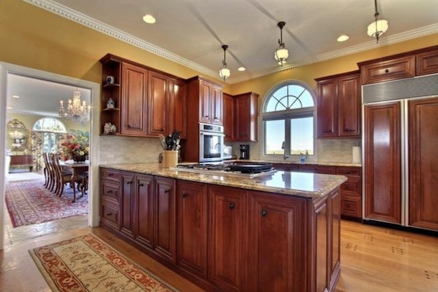 kitchen featuring decorative light fixtures, decorative backsplash, appliances with stainless steel finishes, a notable chandelier, and light stone counters