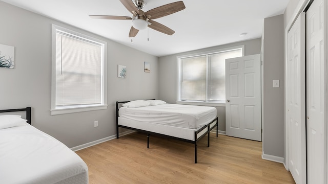 bedroom with a closet, light hardwood / wood-style flooring, and ceiling fan