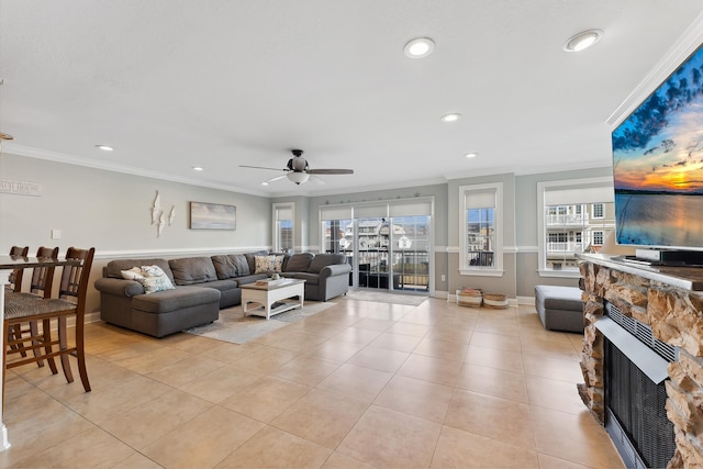 living area with crown molding, a wealth of natural light, a fireplace, and light tile patterned floors