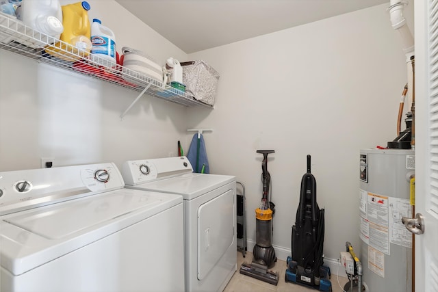 laundry room featuring laundry area, light tile patterned floors, baseboards, washing machine and clothes dryer, and water heater